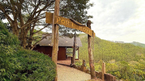 Un letrero de madera indica 'PORT ROYAL', señalando a una cabaña de madera con un camino de grava.