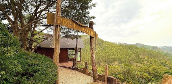 A wooden signpost with 'PORT ROYAL' written on it, leading to a wooden cabin with a gravel path. - ASA Sunset Valley Cabana do Capitao Vista (Jose Boiteux)