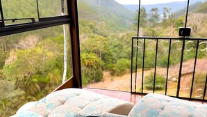 Una habitación con vistas a un paisaje montañoso a través de una ventana.