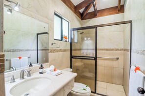 A bathroom with a glass-enclosed shower, a sink with a mirror, and a toilet. - Villa Sol Resort Gem w/ Soaking Pool & Views! (Playa Hermosa)