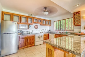 A kitchen with wooden cabinets, a stainless steel refrigerator, a microwave, a stove, and a dishwasher. - Ocean Views: Bahia Pez Vela Resort Condo (Playa Ocotal)