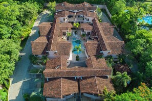 A large resort with multiple buildings, a central swimming pool, and lush greenery surrounding the property. - Sunny 2BR: Balcony, Pool, Kitchen, Walk to Beach (Playa Ocotal)