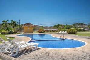 A swimming pool with lounge chairs, a small building, and surrounding greenery. - 3 Mi to Tamarindo & Beach: Cozy 2BR Home (Tamarindo)