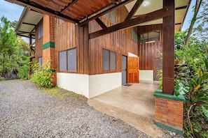 A modern building with a brick facade, large windows, and a covered entrance area. - Lush Jungle Home w/ Chemical-Free Pool & Bar! (Grecia)