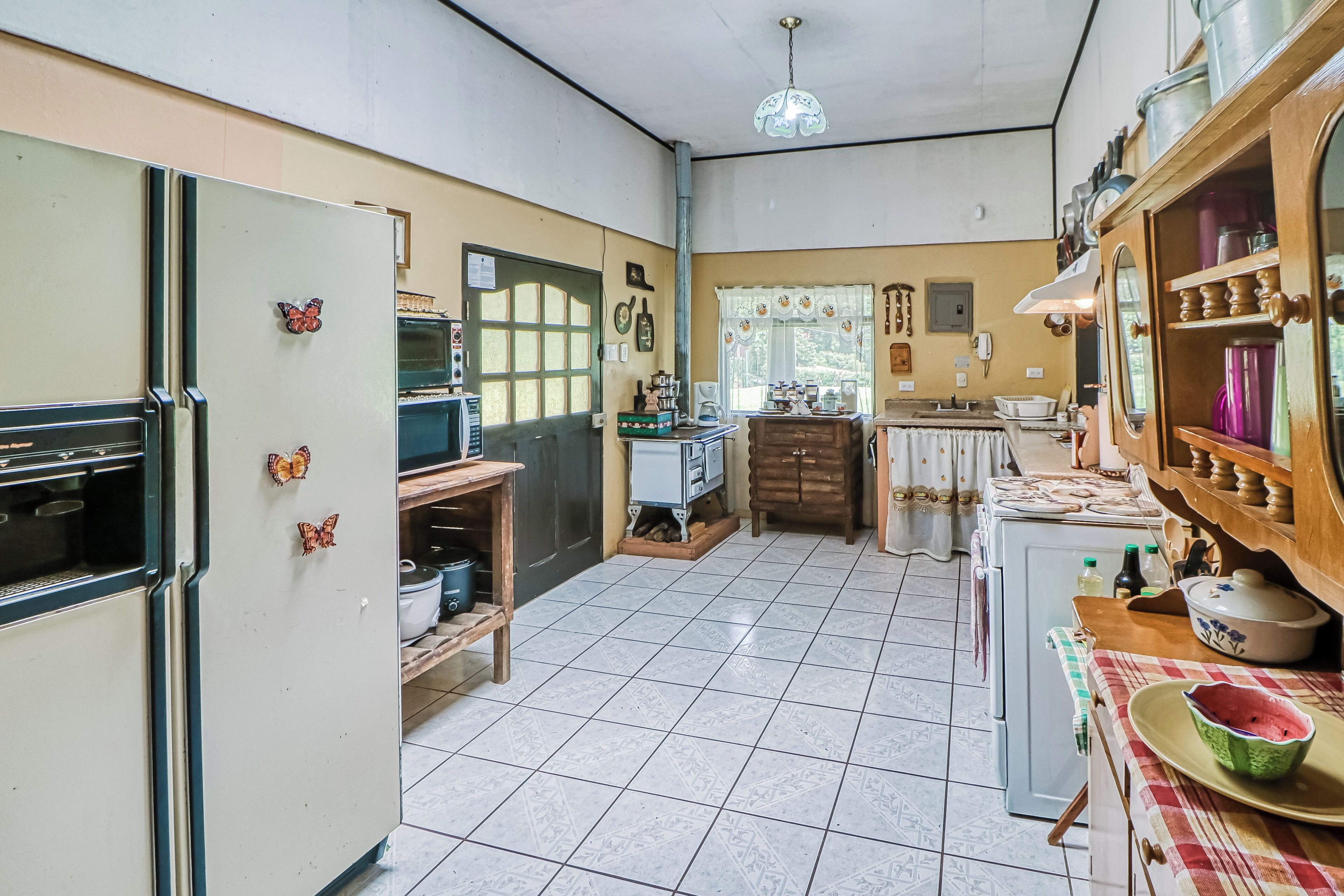 A compact kitchen with a refrigerator, stove, and various kitchen appliances.