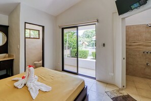A hotel room with a bed, a bathroom, and a view of the outside. - Studio w/ Resort-Style Pool, Walk to Beach! (Playas del Coco)