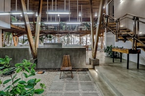 A spacious indoor area with a concrete bench, a wooden chair, and a foosball table. - Award-Winning Oceanfront Home w/ Pool & Hot Tub! (La Javilla)