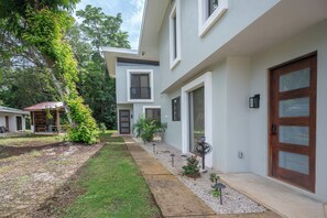 A two-story residential building with a front yard, a wooden deck, and a small garden area. - 5 Mi to Beach: Updated Playa Avellanas Gem (Playa Avellanas)