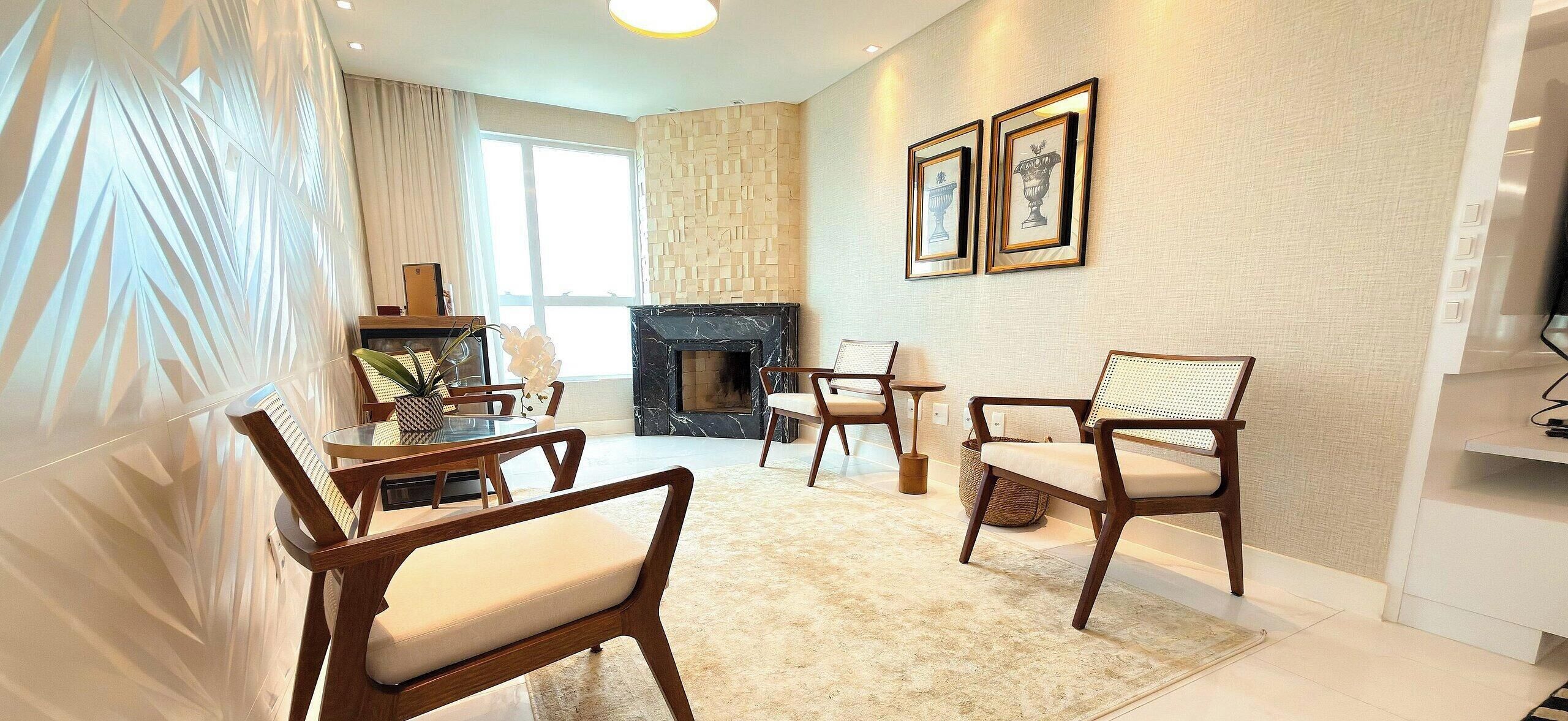 Een woonkamer met een open haard, een eettafel met stoelen en een bank.