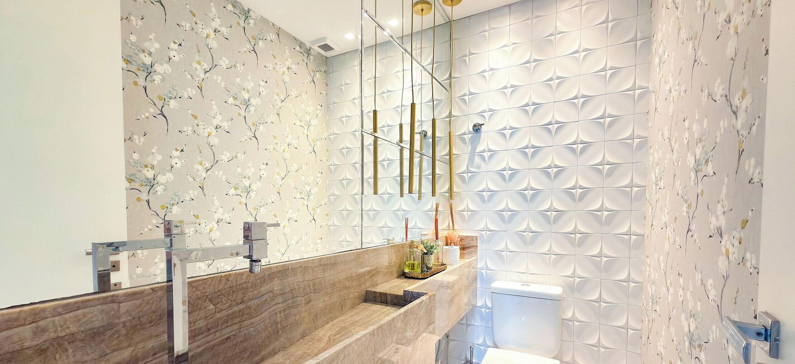 A modern bathroom with a marble sink, a glass partition, and a toilet with a unique geometric tile design.