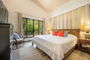 A bedroom with a large bed, a chair, a nightstand, and a window with curtains. - Pool & Large Patio: Playa Carrillo 3BR Family Home (Playa Carrillo)