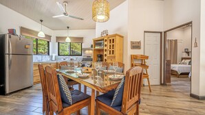 Cozinha moderna com área de refeições, móveis de madeira e ventilador de teto.