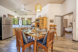 A modern kitchen with a dining area, wooden furniture, and a ceiling fan. - Pool & Large Patio: Playa Carrillo 3BR Family Home (Playa Carrillo)