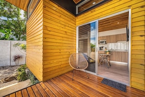 A modern wooden exterior with a sliding glass door leading to a kitchen area. - Private 2-Studio Retreat Near Playa Del Coco! (Playas del Coco)