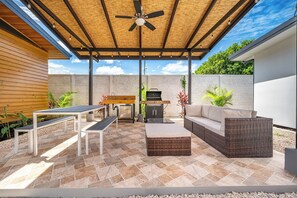 An outdoor patio with a ceiling fan, a barbecue grill, and seating arrangements. - Private 2-Studio Retreat Near Playa Del Coco! (Playas del Coco)