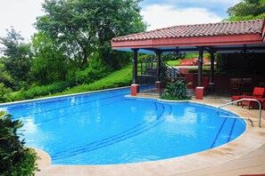A swimming pool with a covered area and lounge chairs. - Playa Conchal Resort Condo w/ Ocean View (Playa Conchal)