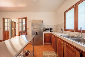 A kitchen with a stainless steel refrigerator, a coffee maker, and a sink. - Santa Cruz Group Getaway w/ Pool: Walk to Beach (Junquillal)