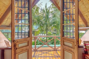 A wooden-framed balcony with a view of tropical foliage. - 'Casita Ballenato' w/ Beach Access & Ocean View (Uvita)