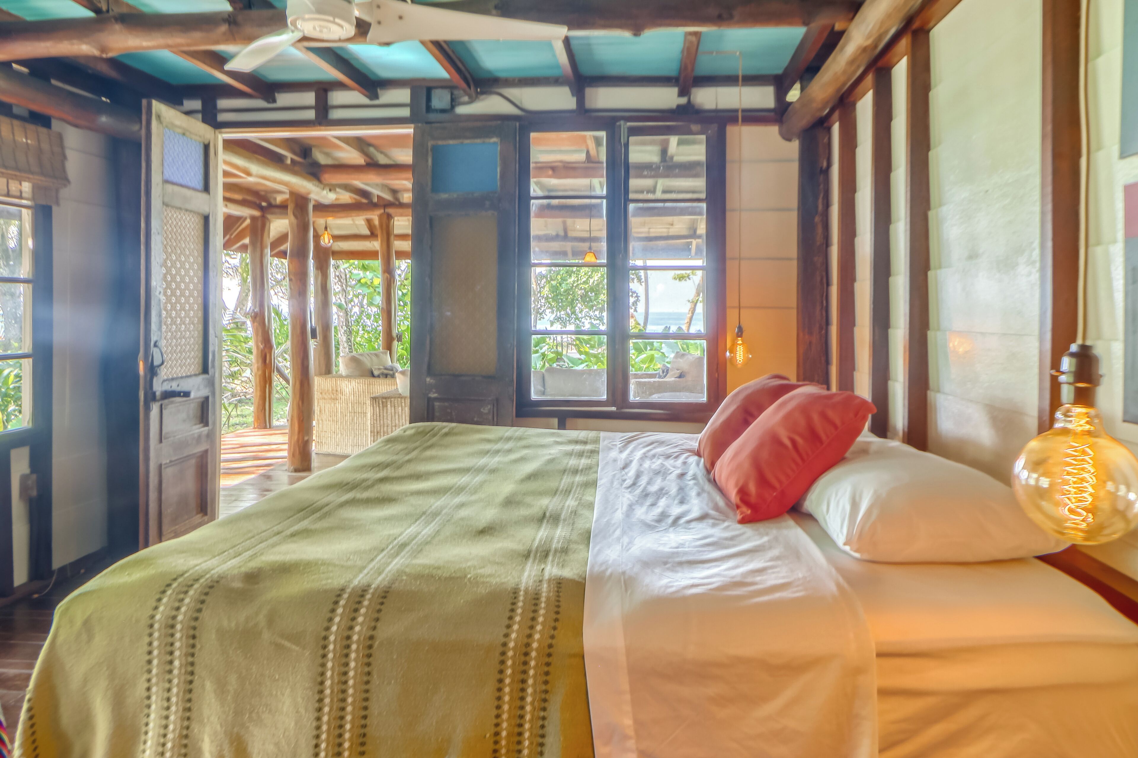 A room with a bed, a window, and a view of the outdoors.
