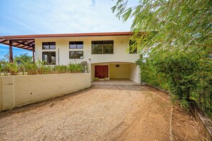 A two-story building with a covered entrance and a gravel driveway. - Luxe Ocean-View Hideaway in Carrillo (Playa Carrillo)