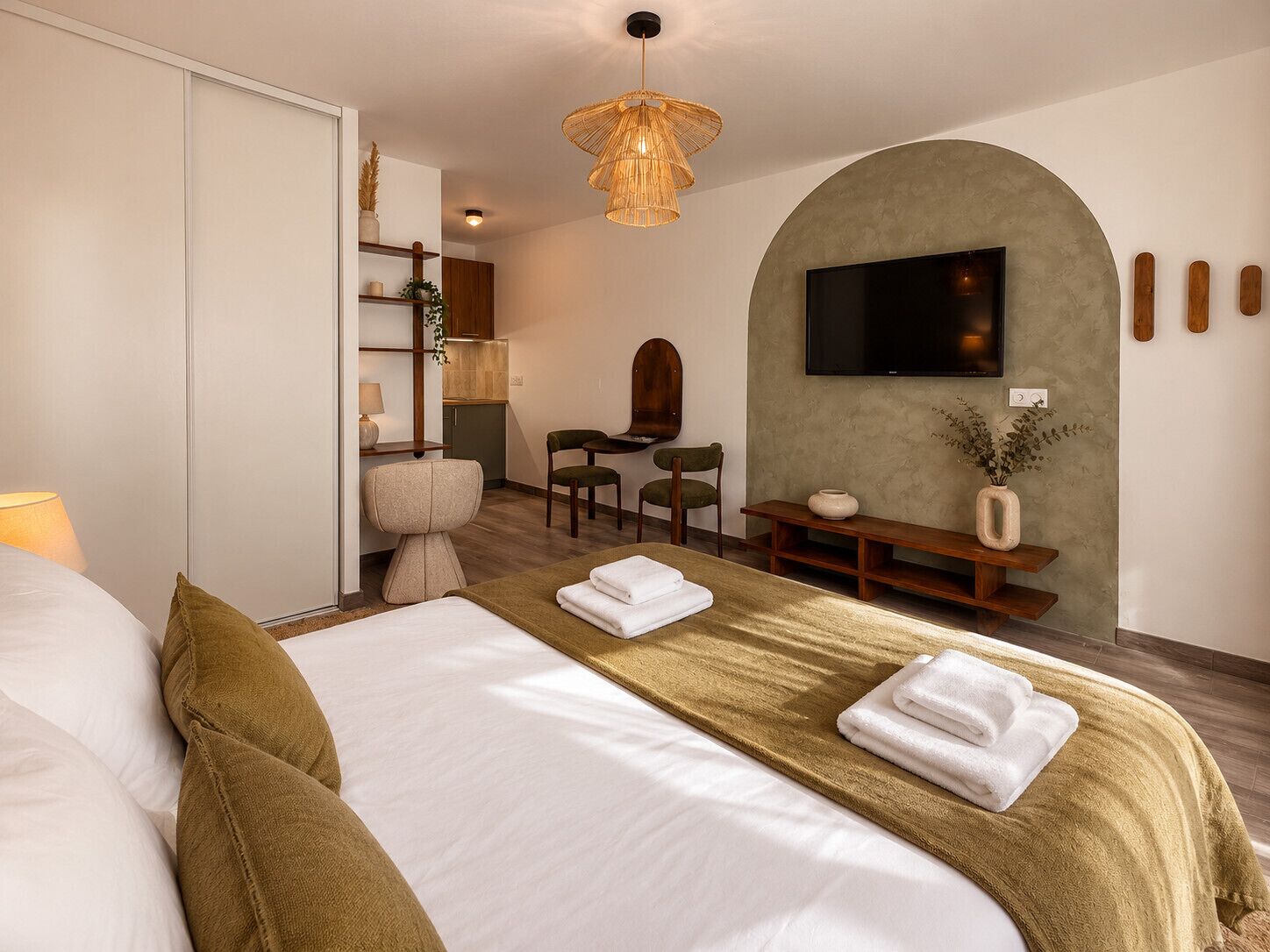 Una habitación de hotel con una cama, un escritorio, un televisor y una zona de estar.