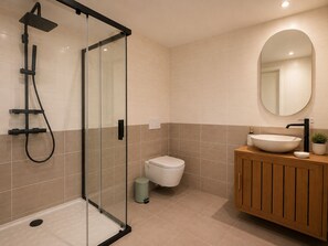 Ein modernes Badezimmer mit Duschkabine aus Glas, Toilette und Waschtisch.