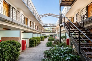 Ein mehrgeschossiges Hotel mit einer zentralen Gangzone und Treppenhäusern auf beiden Seiten, sowie einem überdachten Außenbereich.