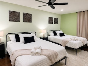 A hotel room with two beds, a ceiling fan, and decorative wall art. - The KC Garden Retreat- 10 Mins to Everything! (Kansas City)