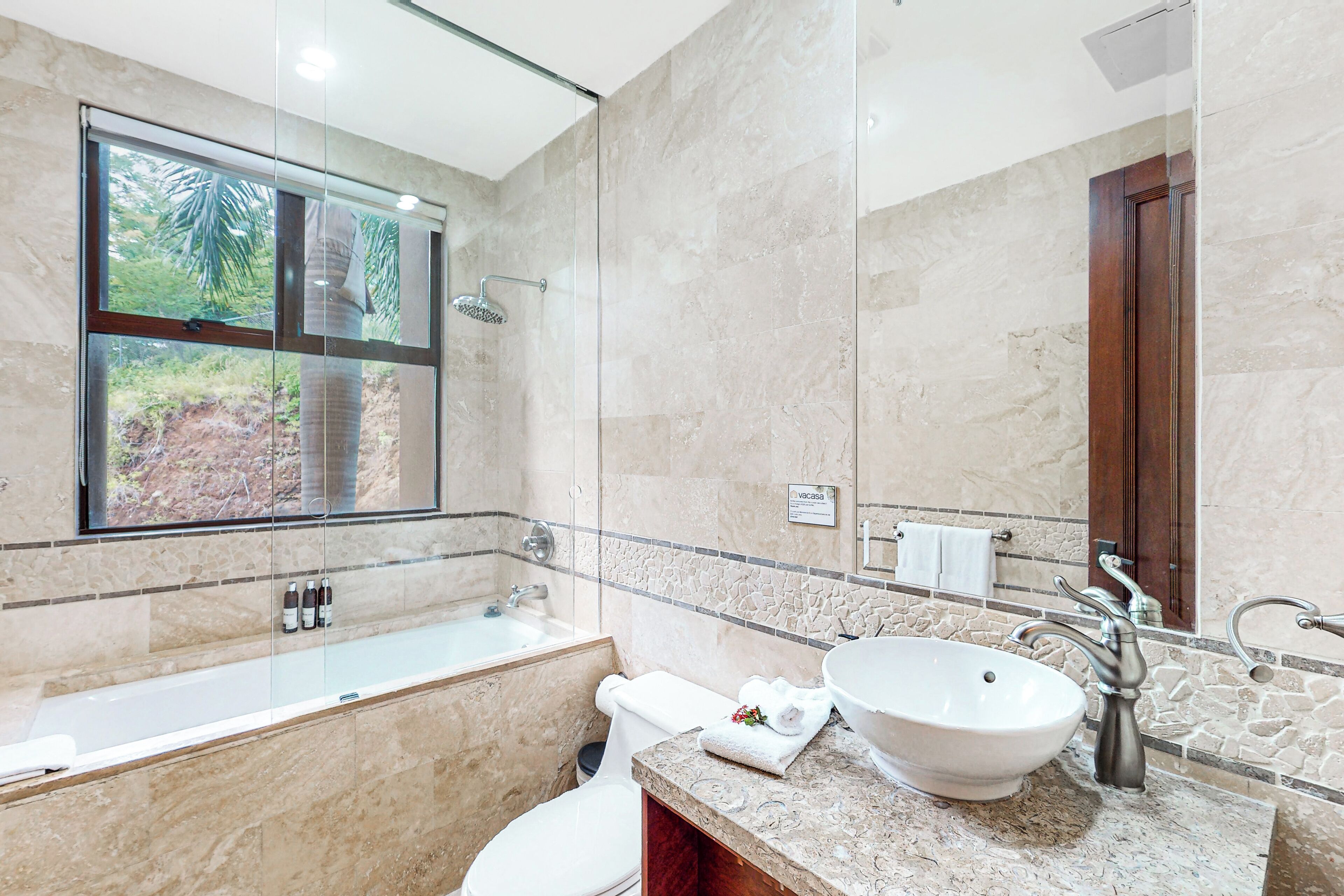Un bagno moderno con una vasca, un lavandino e uno specchio grande.