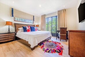 A bedroom with a bed, nightstands, a chair, a TV, and a window with curtains. - Private Pool, Luxe Patio: 4BR Carrillo Villa (Playas del Coco)