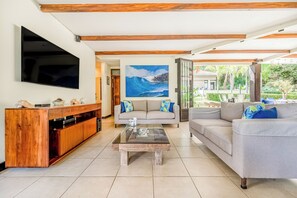 Ein Wohnzimmer mit Flachbildfernseher, Holz-Unterhaltungseinheit, zwei Sofas und einem Couchtisch.