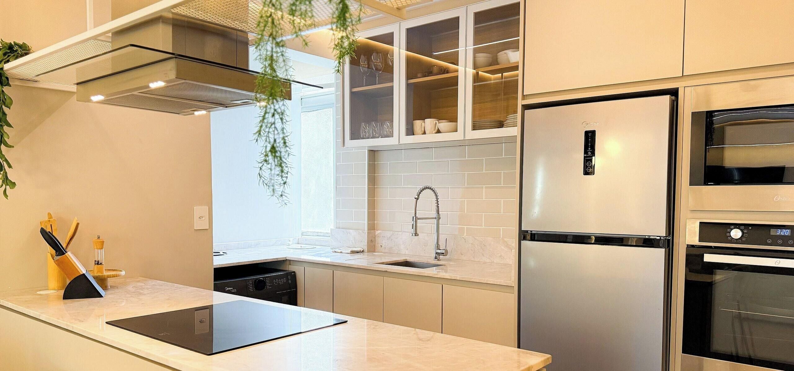 Una cocina moderna con lavavajillas incorporado, refrigerador de acero inoxidable y horno doble.
