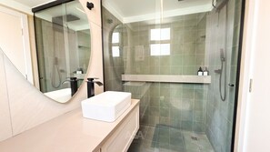 A modern bathroom with a large mirror, a white sink, and a shower area. - ASA 2 Suites Pe na Areia Vista mar BC (Balneário Camboriú)