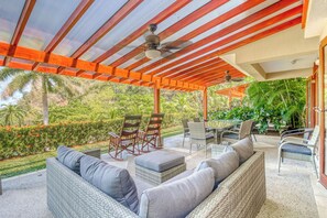 A covered outdoor seating area with wicker furniture and ceiling fans. - 2-Unit Bundle: Bahia Pez Vela Resort Villas (Playa Ocotal)