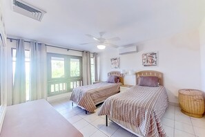 A room with two beds, a ceiling fan, an air conditioner, and a window with curtains. - 2-Unit Bundle: Bahia Pez Vela Resort Villas (Playa Ocotal)