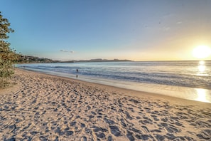 Ein Strand mit Fußspuren und blauem Himmel.