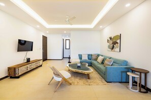 Ein modernes Wohnzimmer mit Sofa, Couchtisch und Fernseher.