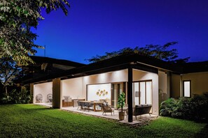 A modern house with a patio area, a dining table, and chairs. - Tamarindo Villa w/ Private Pool, Beach Club Access (Tamarindo)