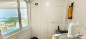 A bathroom with a window, a shower, and a toilet. - ASA Sea View 2BR Apartment Pereque (Porto Belo)