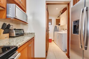 Eine kleine Küche mit Mikrowelle, Toaster und einem Kühlschrank aus Edelstahl.