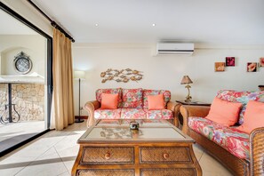 Ein Wohnzimmer mit einer Sofagarnitur, einem Couchtisch und einer Wanddekoration mit Fischmotiven.