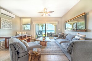 A modern living room with a sofa set, a coffee table, and a dining area. - Playa Potrero Oceanfront: Balcony, Pool (Playa Potrero)