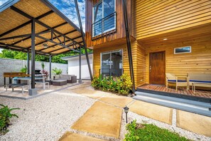 A modern outdoor patio with a pergola, seating area, and a barbecue setup. - Walk to Del Coco Beach & Restaurants: 2 Condos! (Playas del Coco)