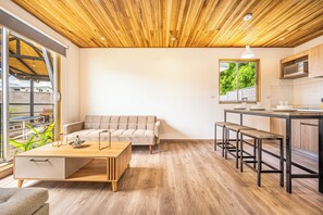 A modern interior with a wooden ceiling, a sofa, a dining table, and a kitchen area. - Walk to Del Coco Beach & Restaurants: 2 Condos! (Playas del Coco)