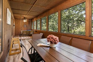 A wooden interior with a long table, benches, and large windows. - Luxury in the Ozarks-Four  Master Bedroom Suites, Sleeps 14, Lots of Space for the Whole Family!-20 (Branson)