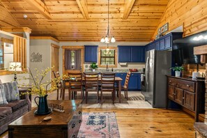 A wooden interior with a dining area, kitchen, and living space. - Luxury in the Ozarks-Four  Master Bedroom Suites, Sleeps 14, Lots of Space for the Whole Family!-20 (Branson)
