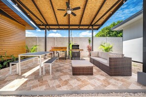 A covered outdoor patio with a ceiling fan, a barbecue grill, a dining table with benches, and a sofa. - 'Veranera' Condo w/ Pool Access, 1/2 Mi to Beach! (Playas del Coco)