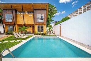 A modern two-story building with a swimming pool, outdoor seating, and a well-maintained garden. - 'Veranera' Condo w/ Pool Access, 1/2 Mi to Beach! (Playas del Coco)