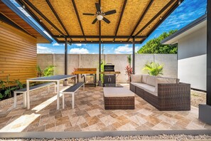 A covered outdoor patio with a ceiling fan, a barbecue grill, and seating arrangements. - Modern Studio w/ Pool Access Near Playas Del Coco! (Playas del Coco)