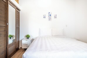 A bedroom with a bed, a nightstand, a dresser, a mirror, and wall art. - Studio w/ Shared Pool < 1 Mi to Playas Del Coco! (Playas del Coco)